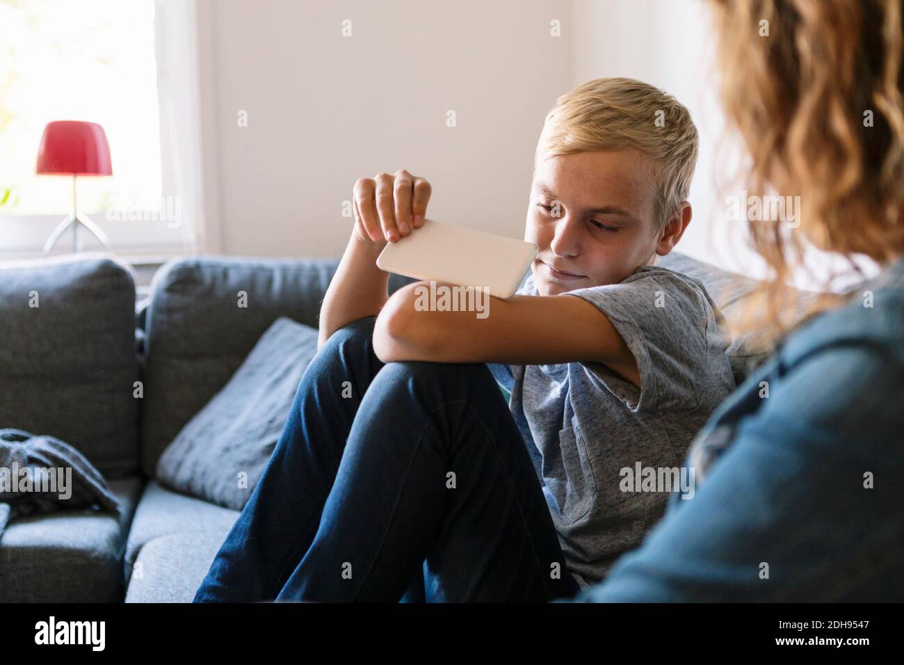 Fils triste assis avec une mère sur un canapé à la maison Banque D'Images