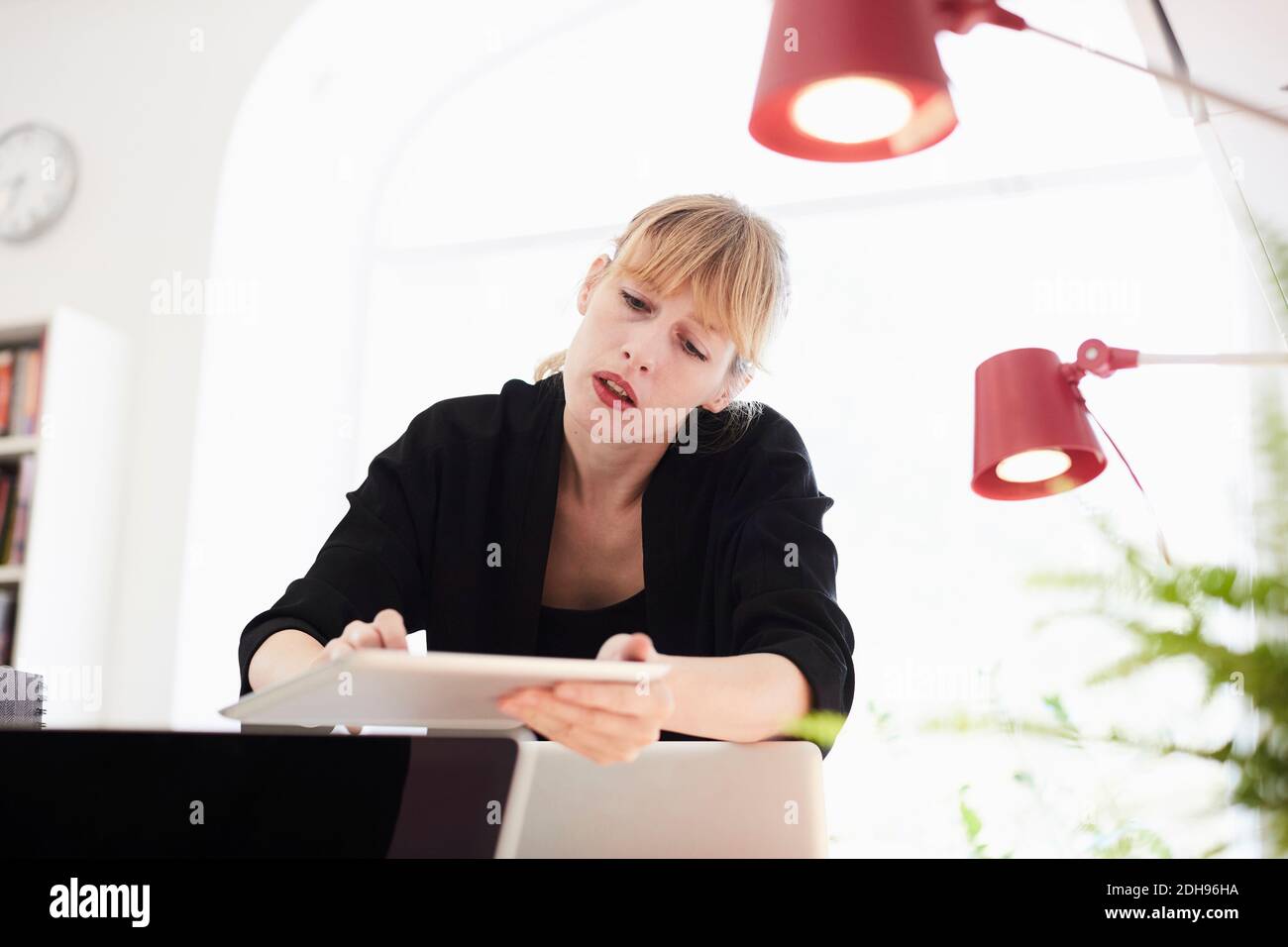Femme d'affaires moyenne adulte utilisant une table numérique au bureau Banque D'Images