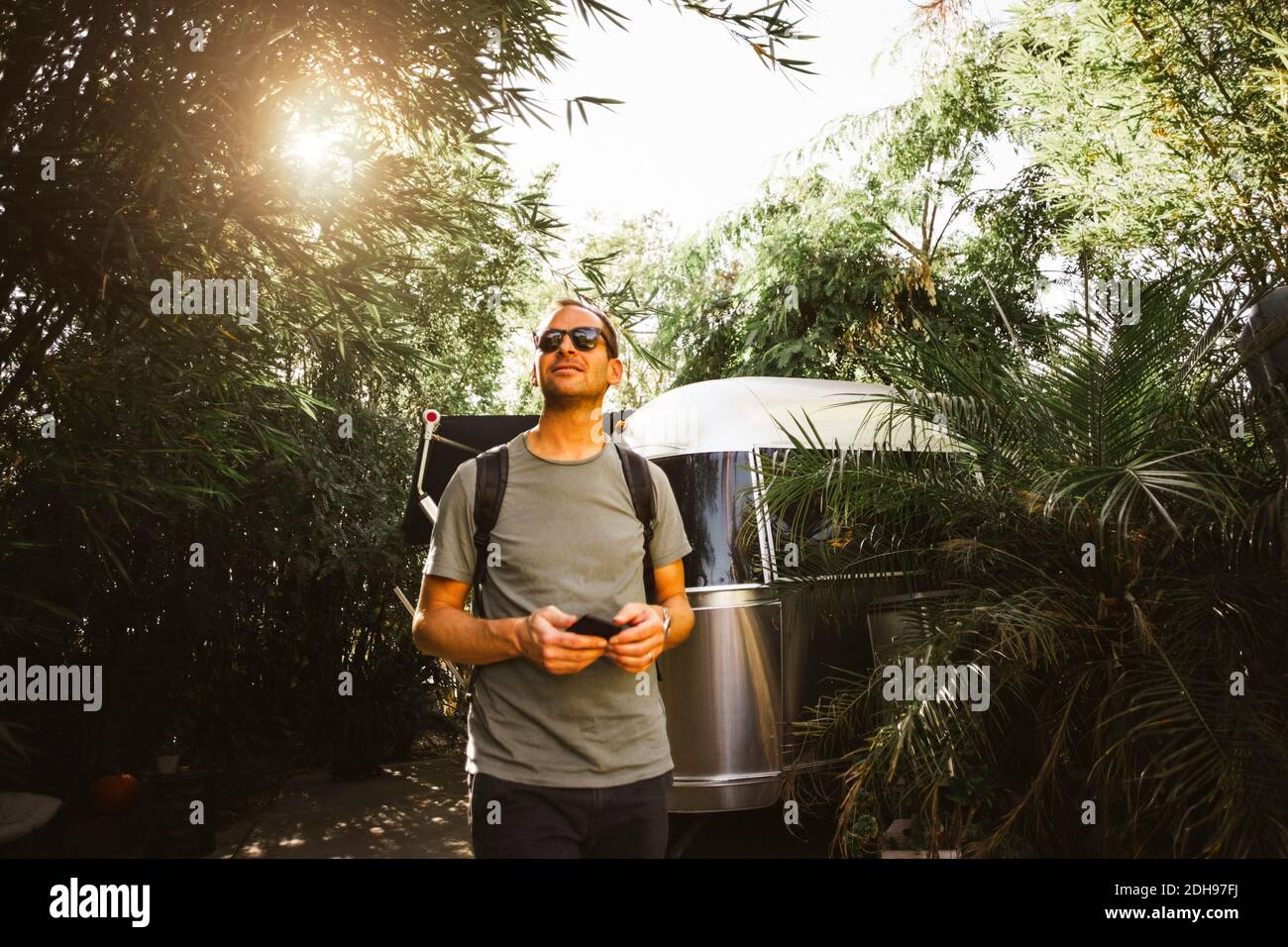 Homme regardant loin en marchant à côté de la maison de moteur Banque D'Images