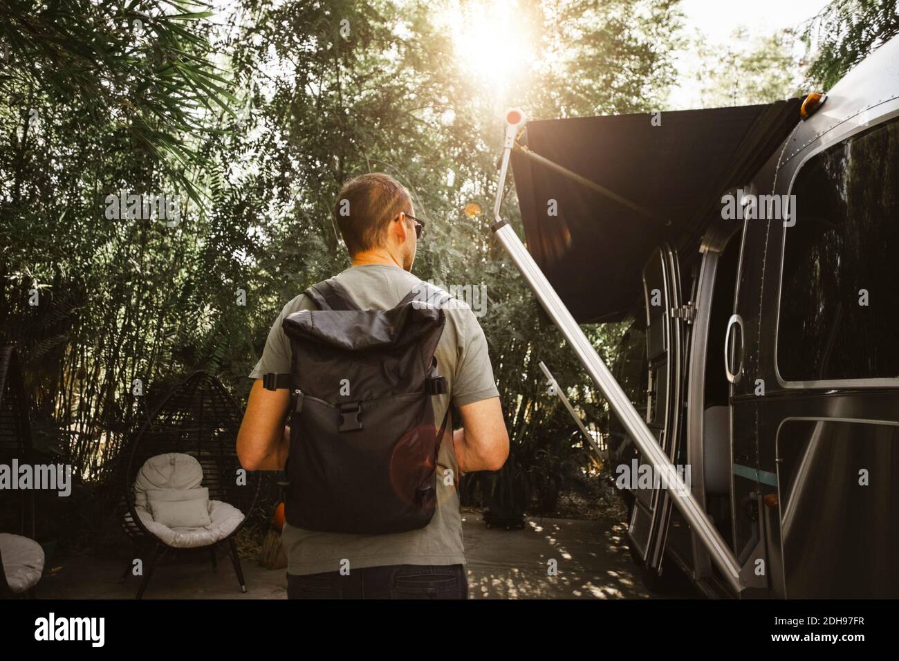 Vue arrière de l'homme avec sac marchant à côté de la maison de moteur Banque D'Images