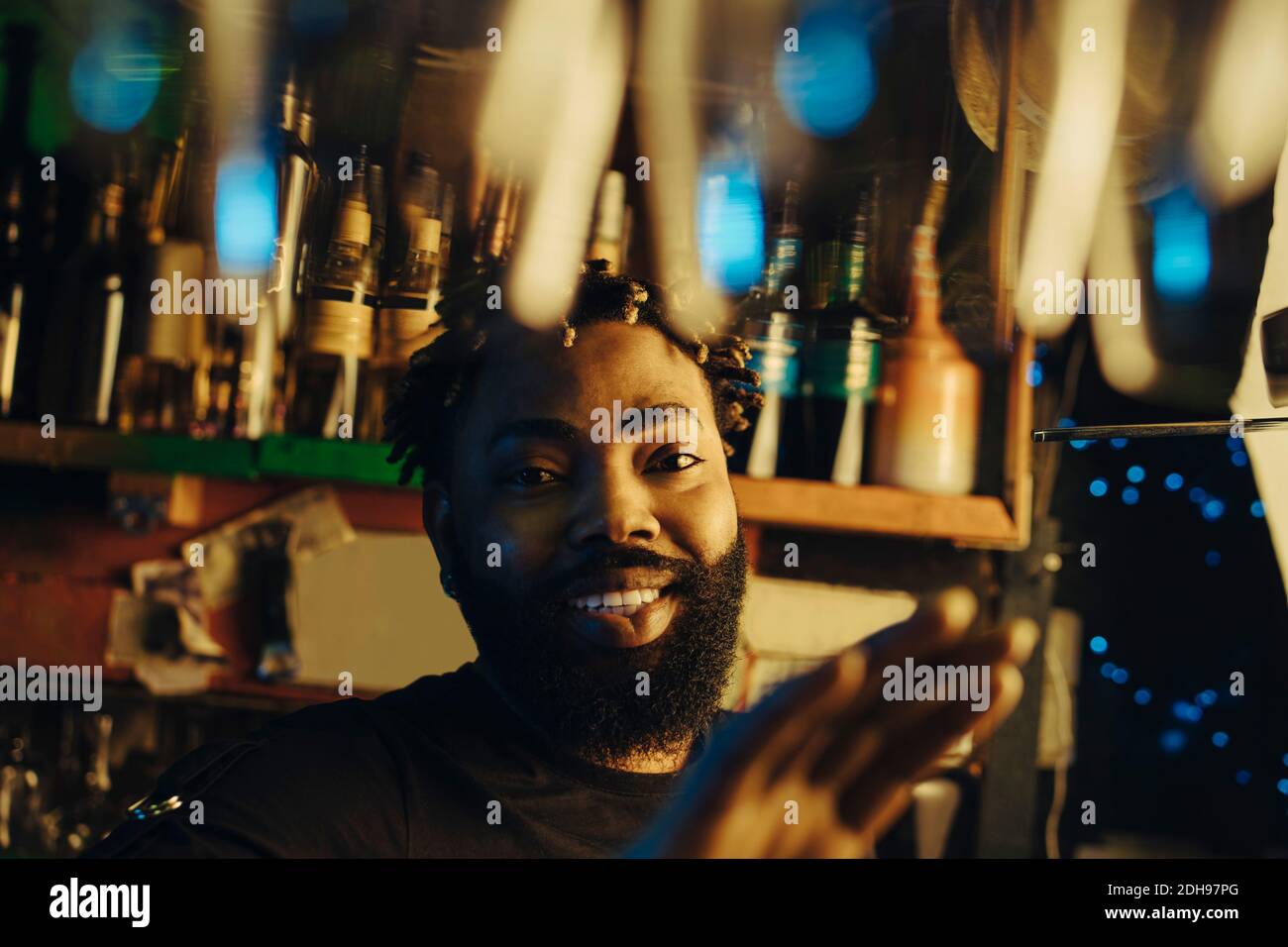 Portrait d'un barman souriant avec une coiffure afro à illuminé Banque D'Images