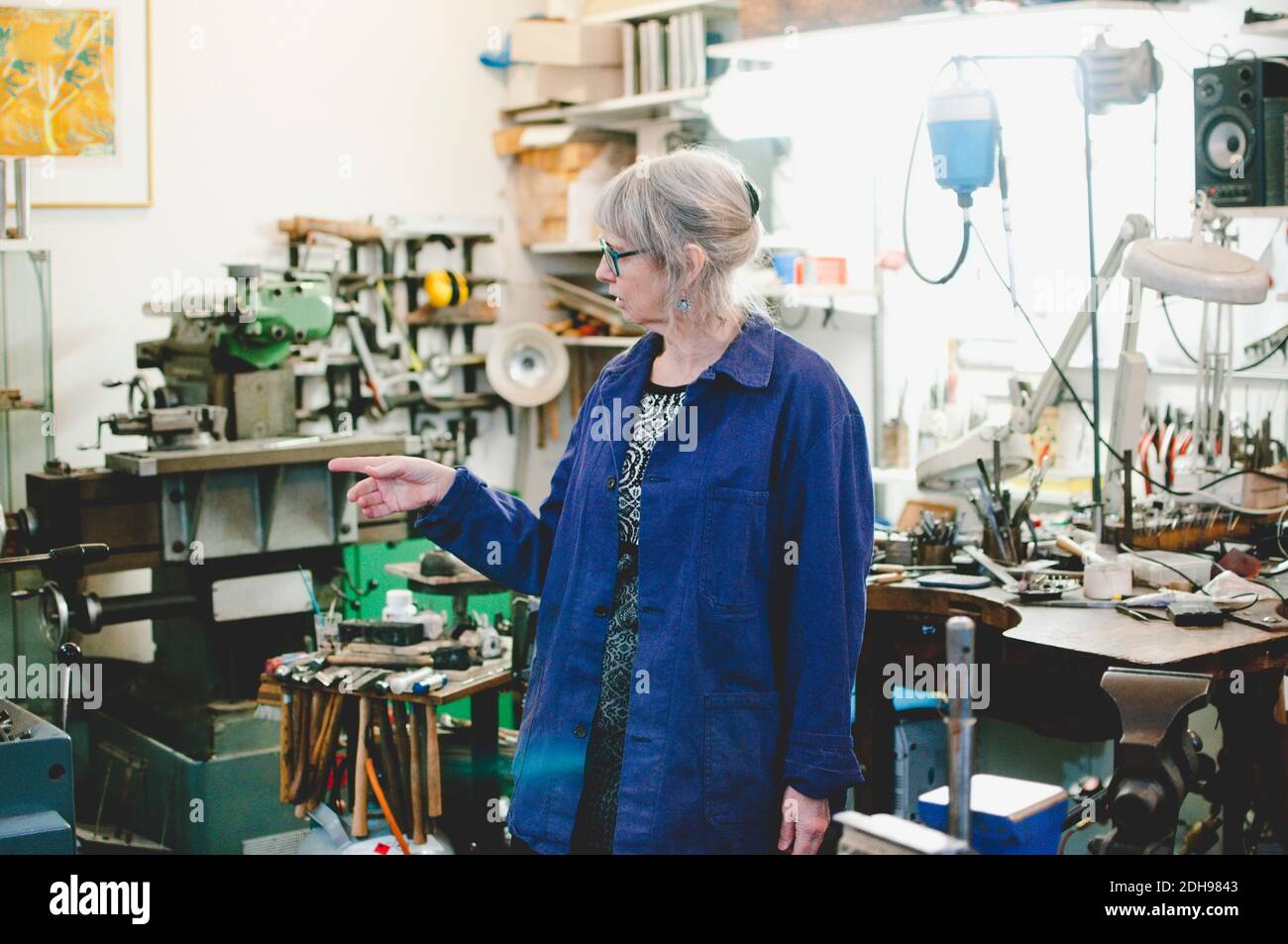 Une femme d'artisan senior qui pointe dans un atelier de bijoux Banque D'Images