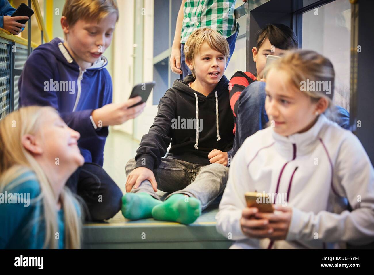 Jeunes lycéens avec téléphones mobiles à l'école Banque D'Images