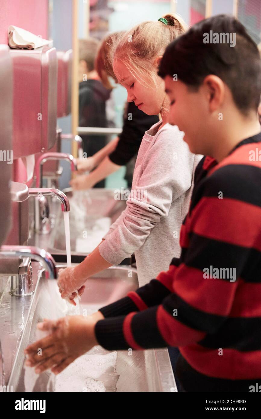 Les jeunes élèves du secondaire se lavent les mains à l'école Banque D'Images