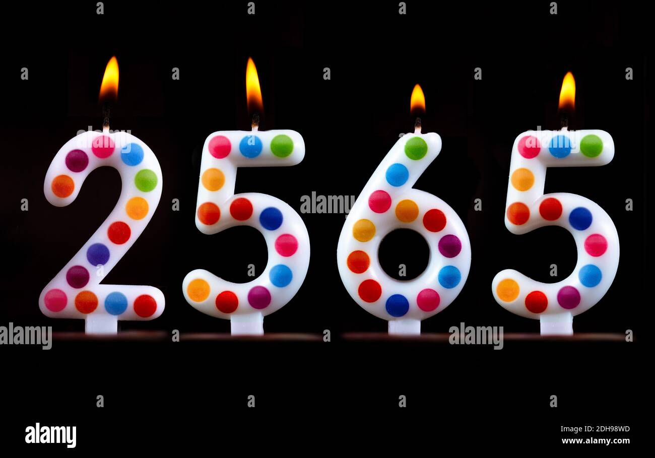 Bougies de couleur écrire des chiffres flamme Thaïlande nouvel an 2565 noir arrière-plan Banque D'Images