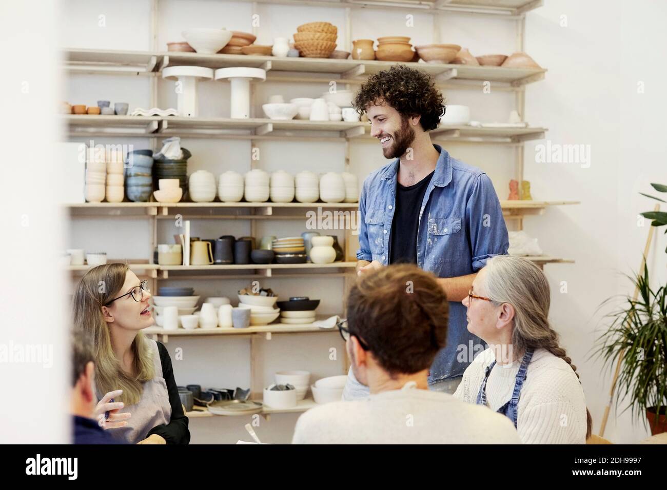 Homme souriant parlant avec une femme en cours d'art Banque D'Images