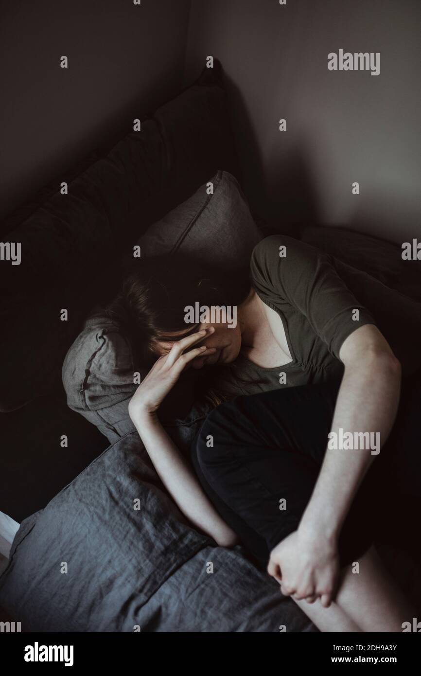 Vue en grand angle de la jeune femme allongé sur le lit à accueil Banque D'Images
