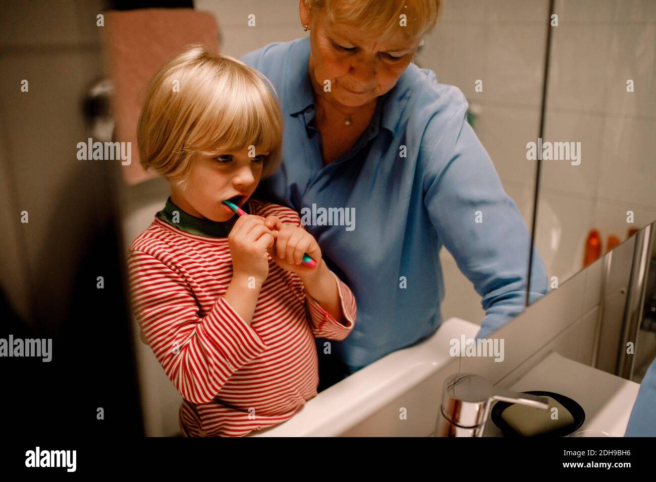 Grand-mère avec petit-fils se brossant les dents dans la salle de bains à la maison Banque D'Images
