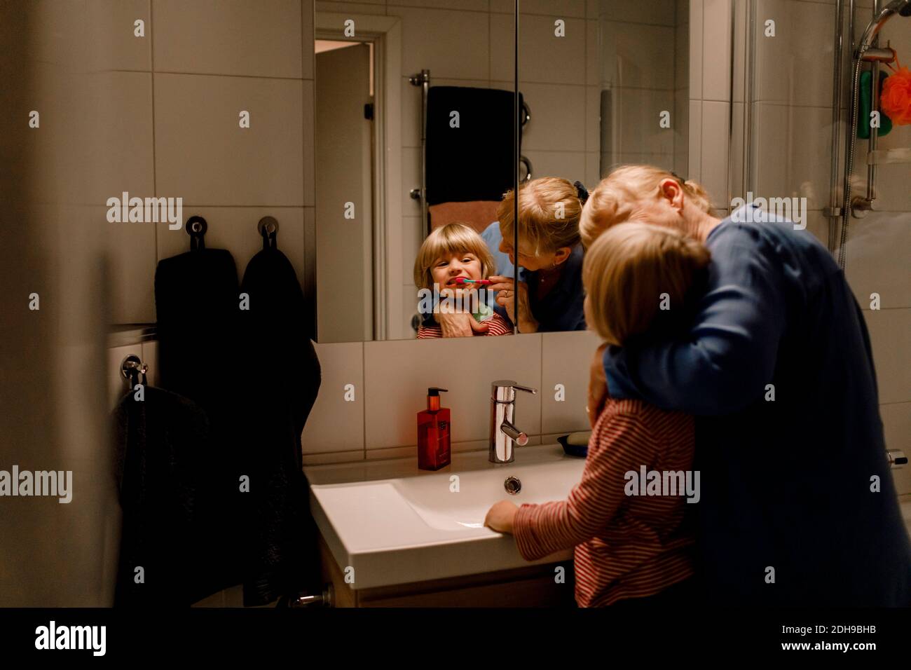Grand-mère se brossant les dents du petit-fils dans la salle de bains à la maison Banque D'Images
