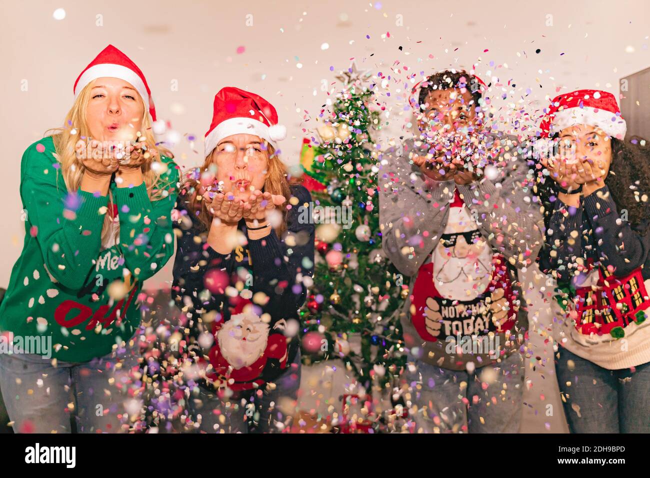 Famille magnifique confetti soufflants. Différentes générations portent des vêtements d'hiver chauds et élégants. Concept de Noël, nouvel an et hiver. Concentrez-vous sur le centre Banque D'Images