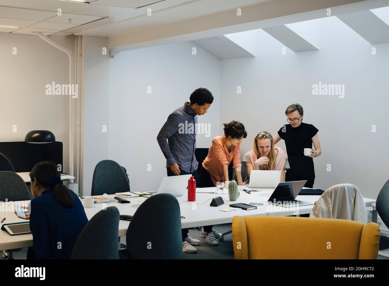 Une équipe de professionnels discutant avec un ordinateur portable dans la salle du conseil pendant la réunion Banque D'Images