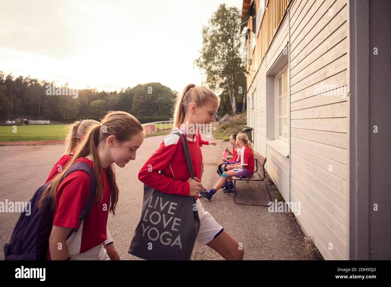 Les filles marchent sur le sentier de marche par mur contre le ciel Banque D'Images