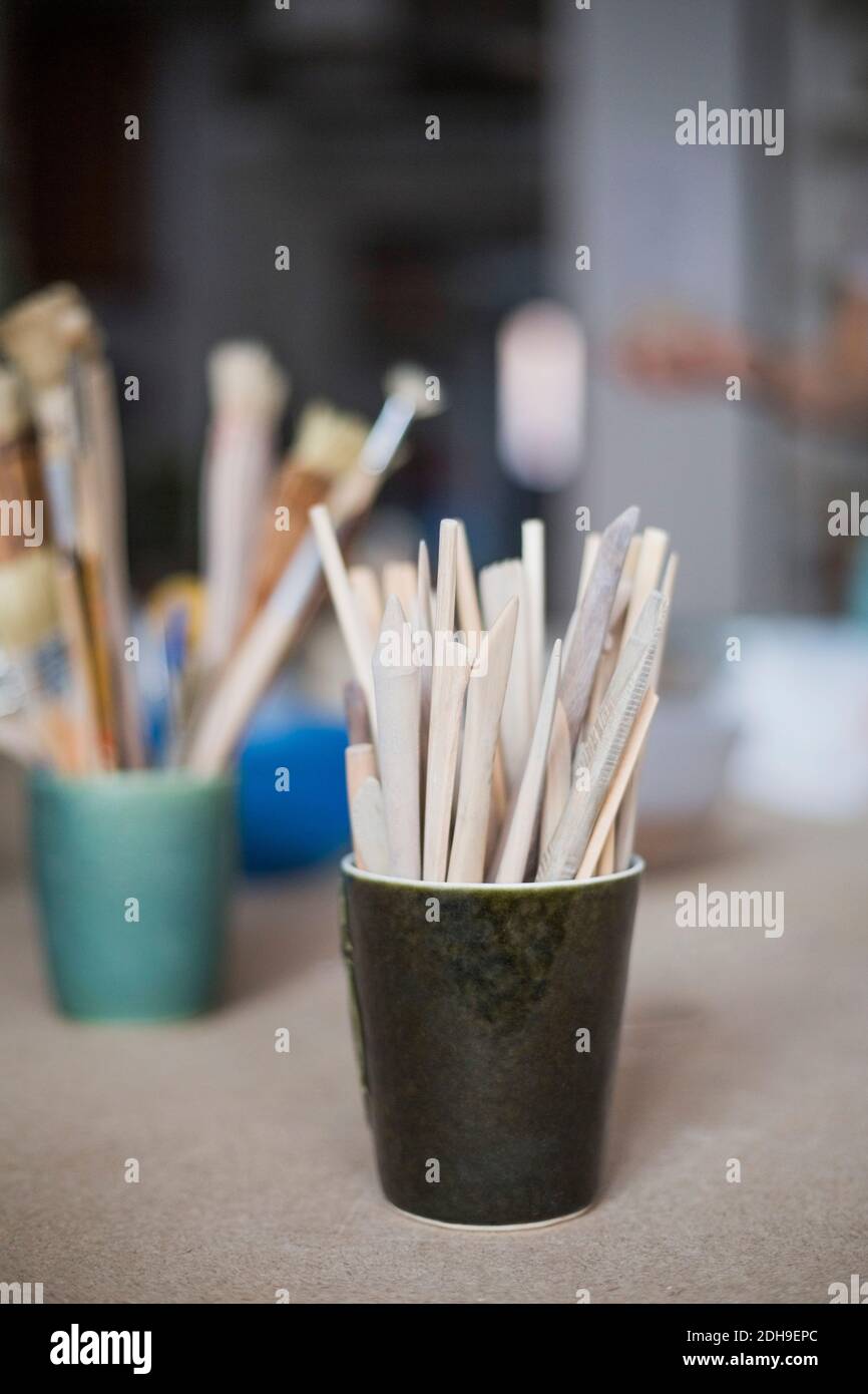 Outils en bois dans un récipient sur la table à l'atelier Banque D'Images