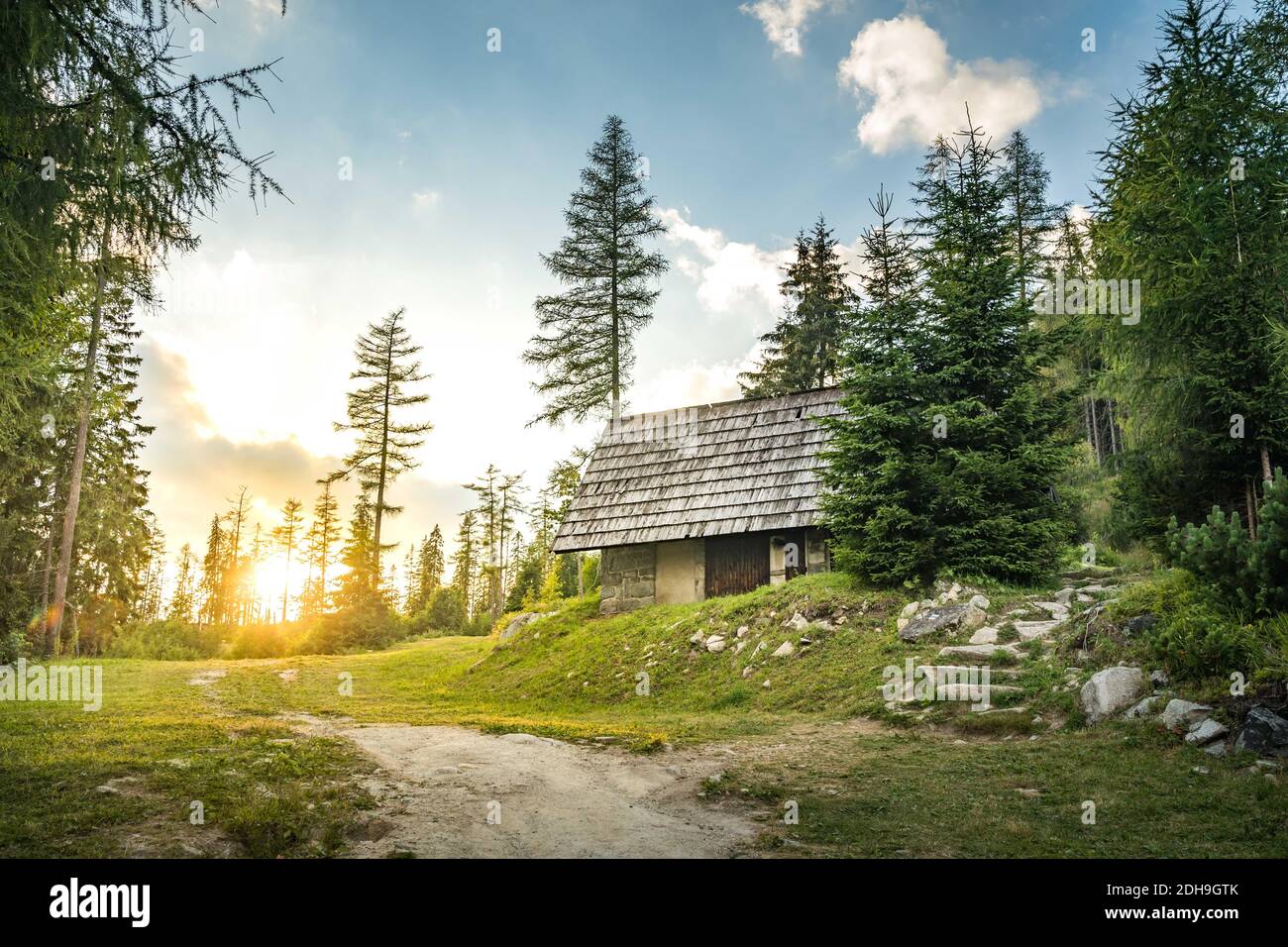 Chalet isolé dans les montagnes entouré de Forrest profond, coucher de soleil en arrière-plan avec des rayons de soleil. Slovaquie montagnes Tatra, Strbske Pleso. Banque D'Images