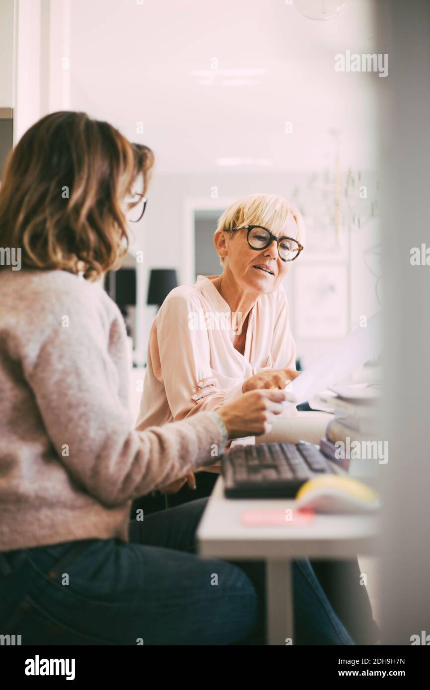 Deux femmes d'affaires au bureau à domicile ayant une discussion Banque D'Images