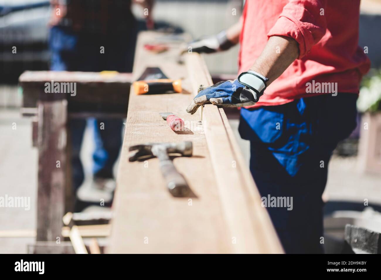 Section médiane de la femme âgée debout sur une planche en bois dans la cour par beau temps Banque D'Images