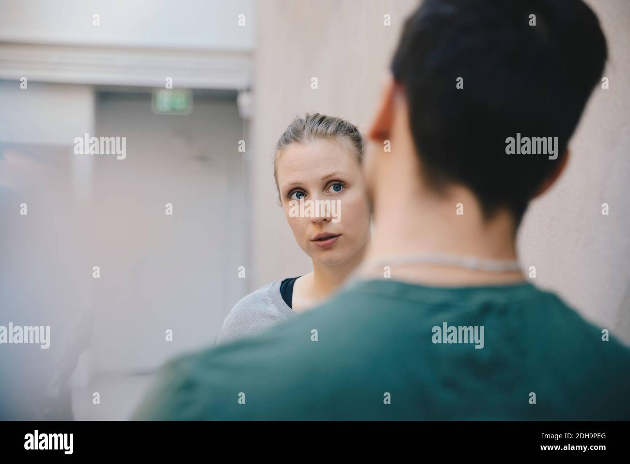 Une programmeur informatique féminine discute avec un collègue au bureau Banque D'Images