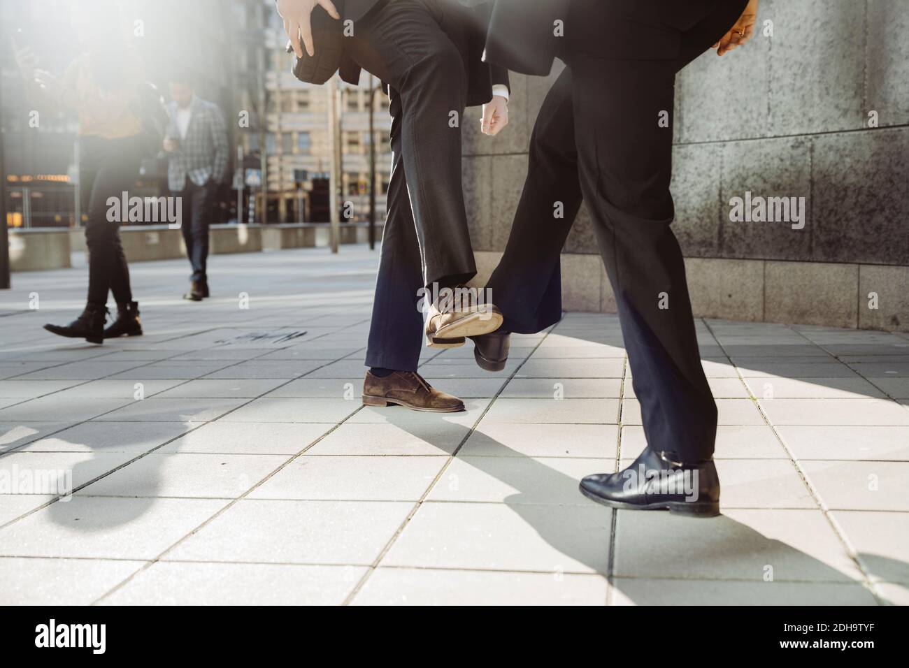 Les gens d'affaires saluent avec les pieds pendant la pandémie Banque D'Images