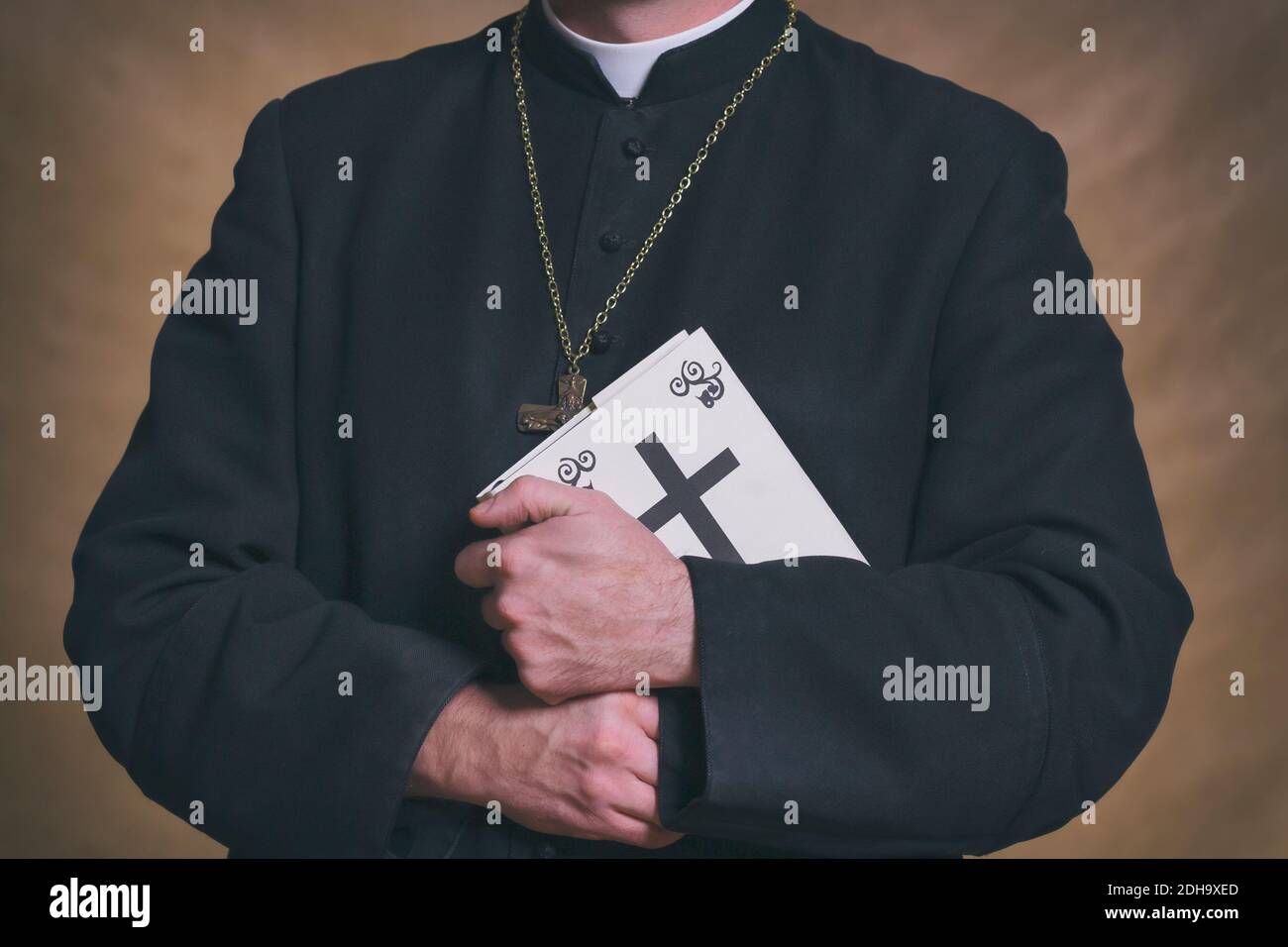 Les mains du prêtre catholique tiennent la sainte bible Banque D'Images