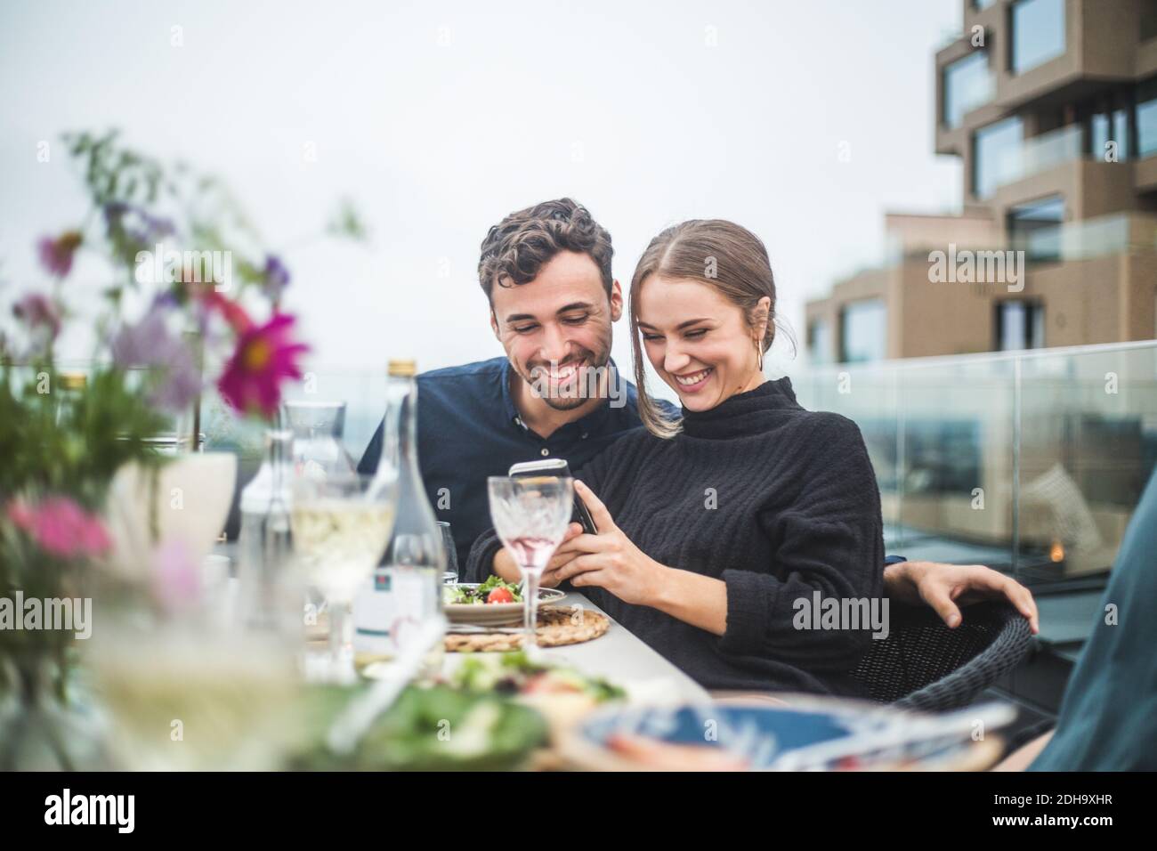 Des amis hommes et femmes heureux utilisant une photographie de téléphone sur le toit fête Banque D'Images