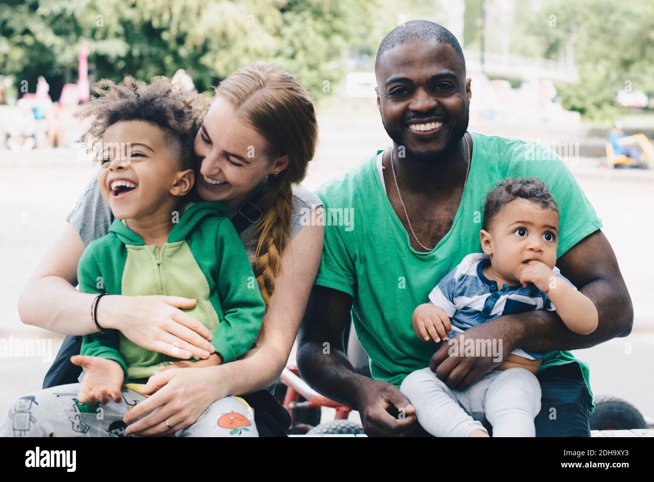 Bonne famille assise au parc Banque D'Images