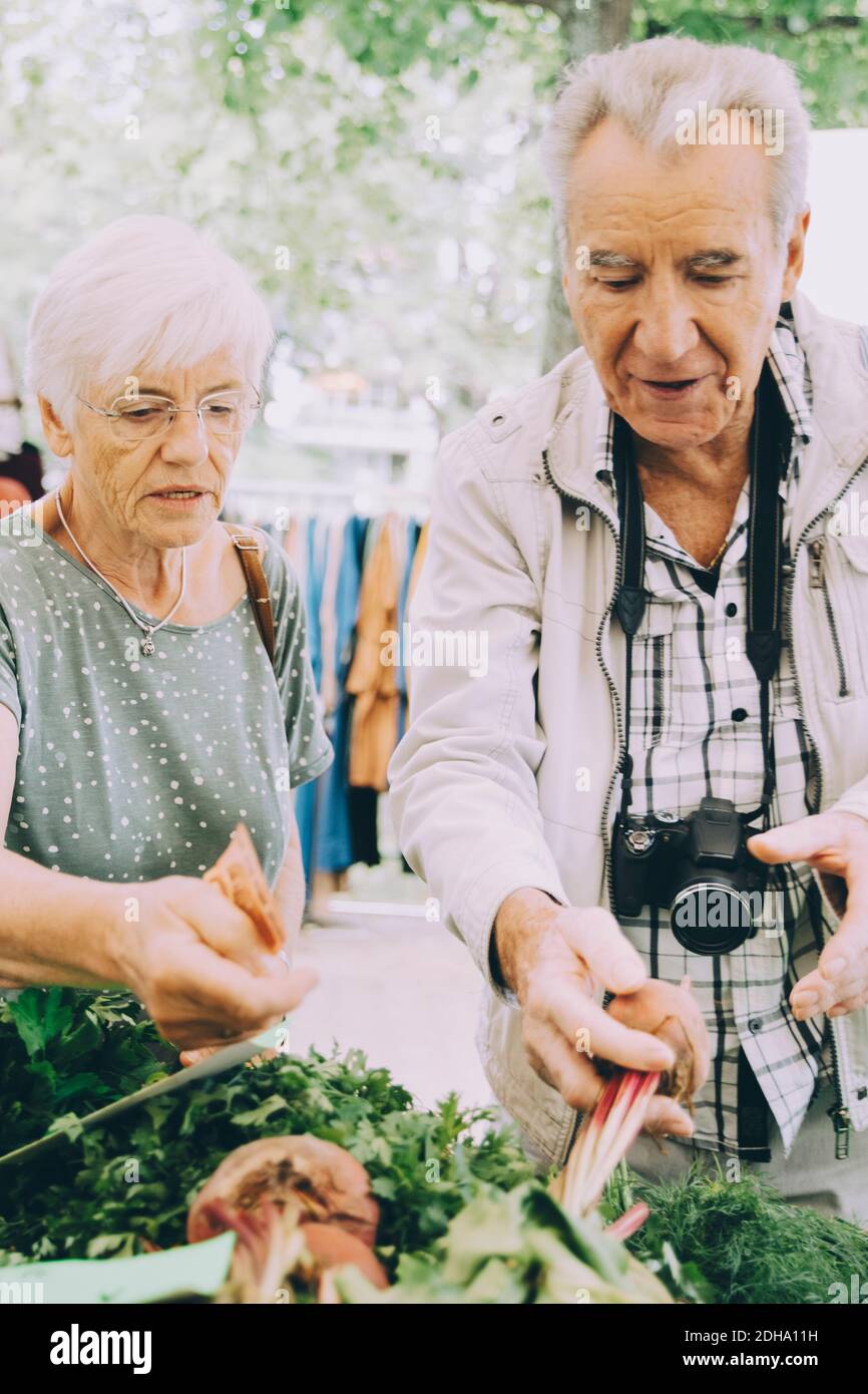 Un homme et une femme de premier plan magasinent pour des légumes sur le marché de la rue en ville Banque D'Images