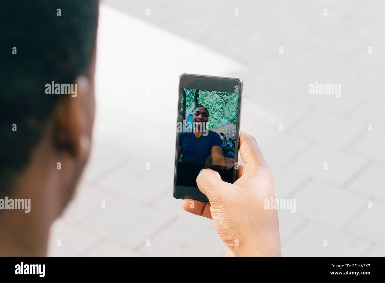 Image rognée d'un jeune homme prenant un selfie sur un smartphone Banque D'Images