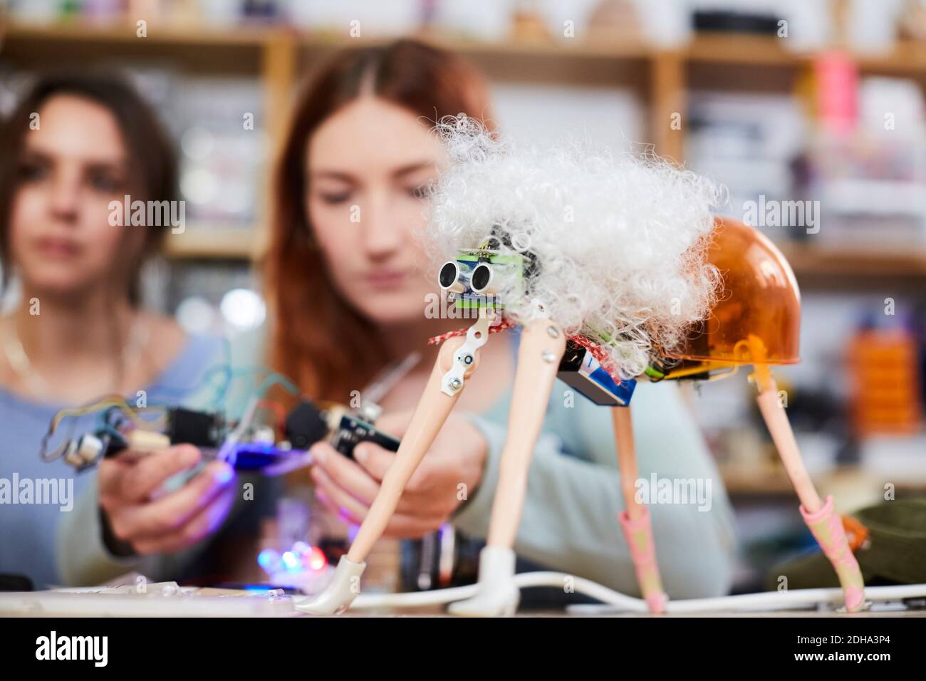 Jeunes inventeurs féminins qui font un modèle de robot à l'atelier Banque D'Images