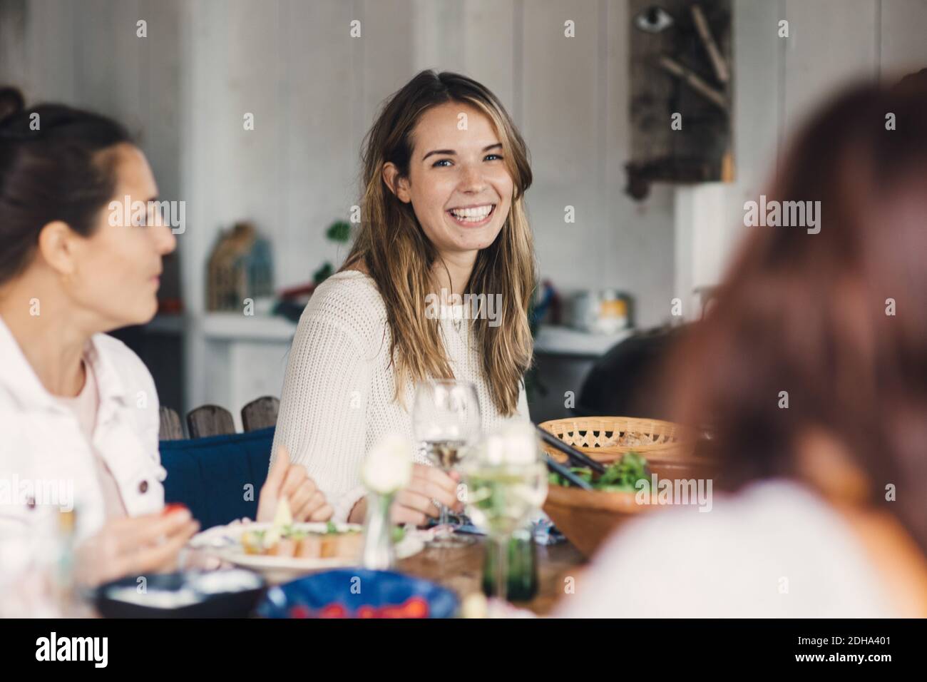 De jeunes amies joyeuses qui s'amusent à la table à manger pendant le déjeuner fête Banque D'Images