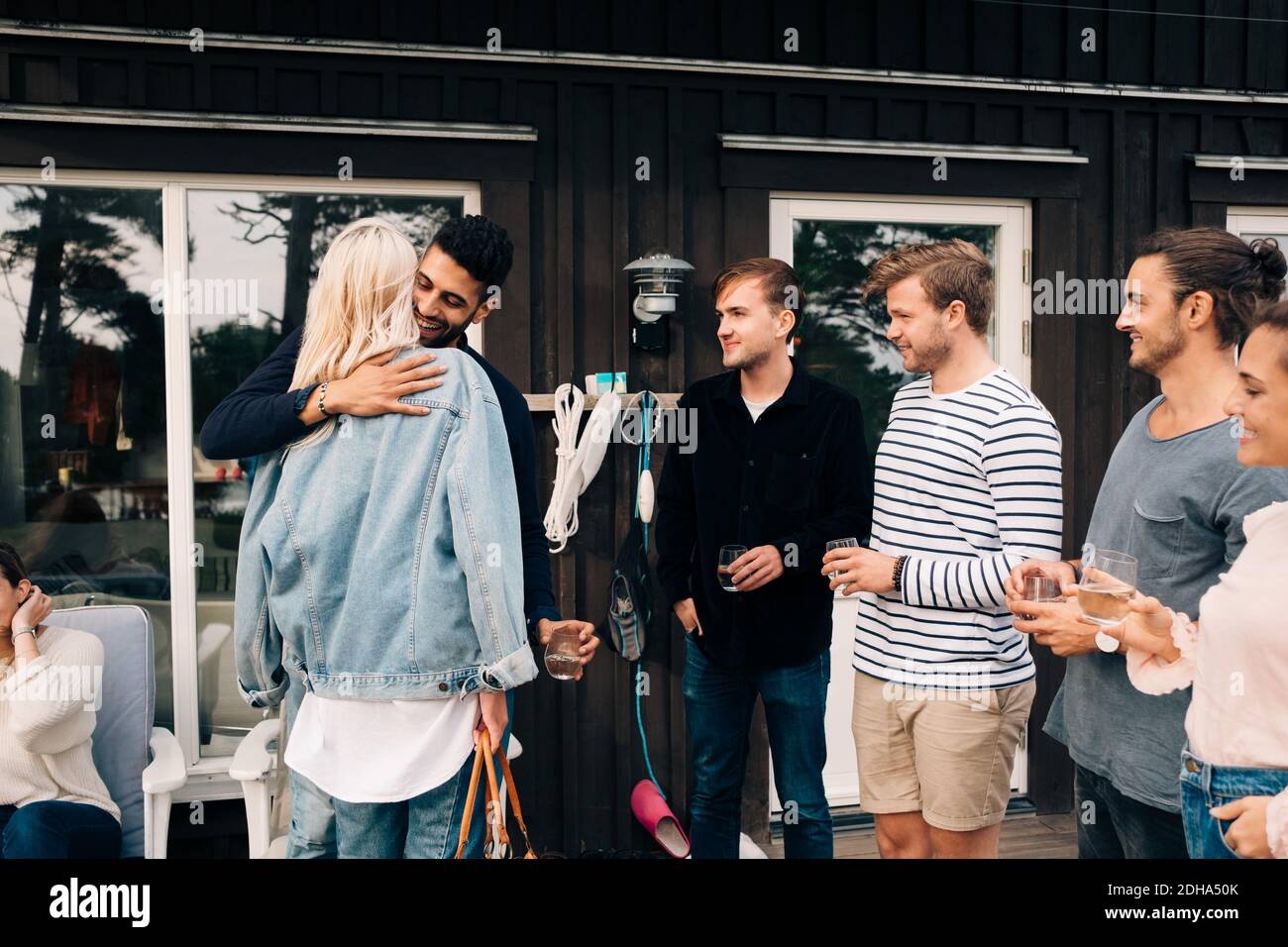 Des amis se saluant les uns les autres à l'extérieur du cottage Banque D'Images