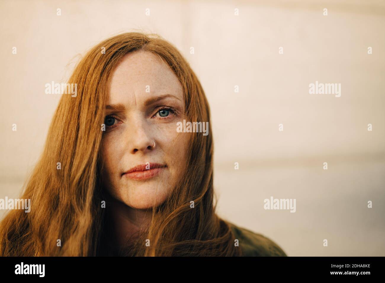 Portrait d'une femme avec de longs cheveux contre le mur Banque D'Images