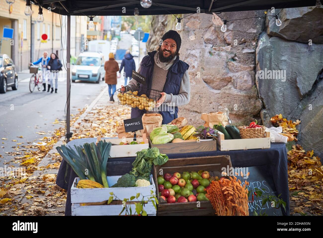 Portrait de l'homme heureux debout avec panier de légumes au marché calage Banque D'Images