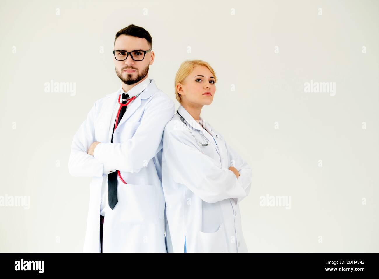Confident doctors standing sur fond blanc avec les bras croisés. Concept de l'équipe de soins médicaux professionnels. Banque D'Images