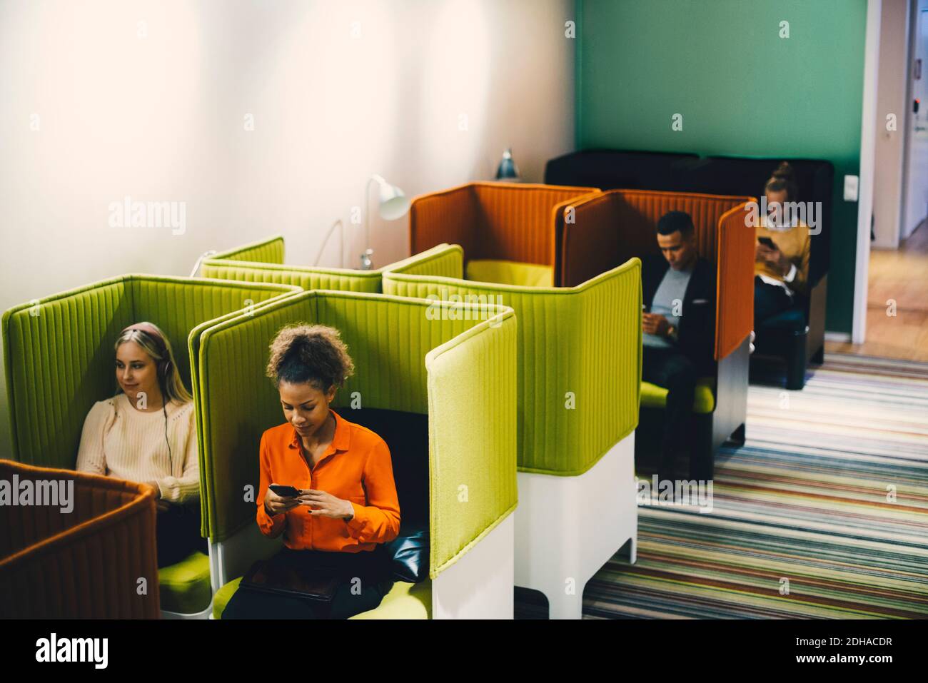 Vue en grand angle des collègues d'affaires multiethniques assis sur des chaises au bureau Banque D'Images