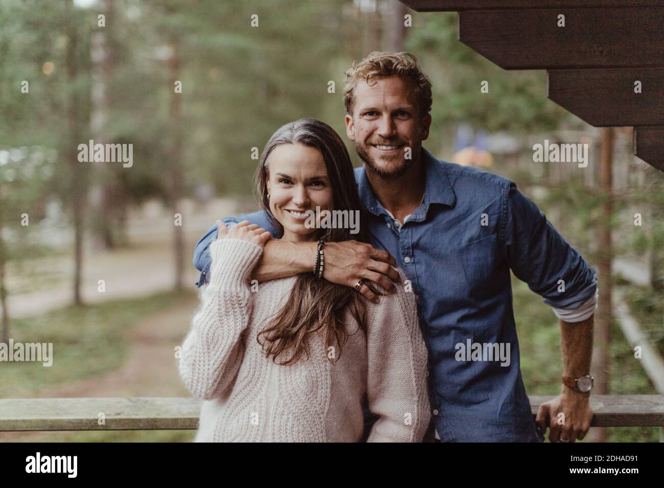 Portrait d'un couple souriant avec le bras autour de la main courante Banque D'Images