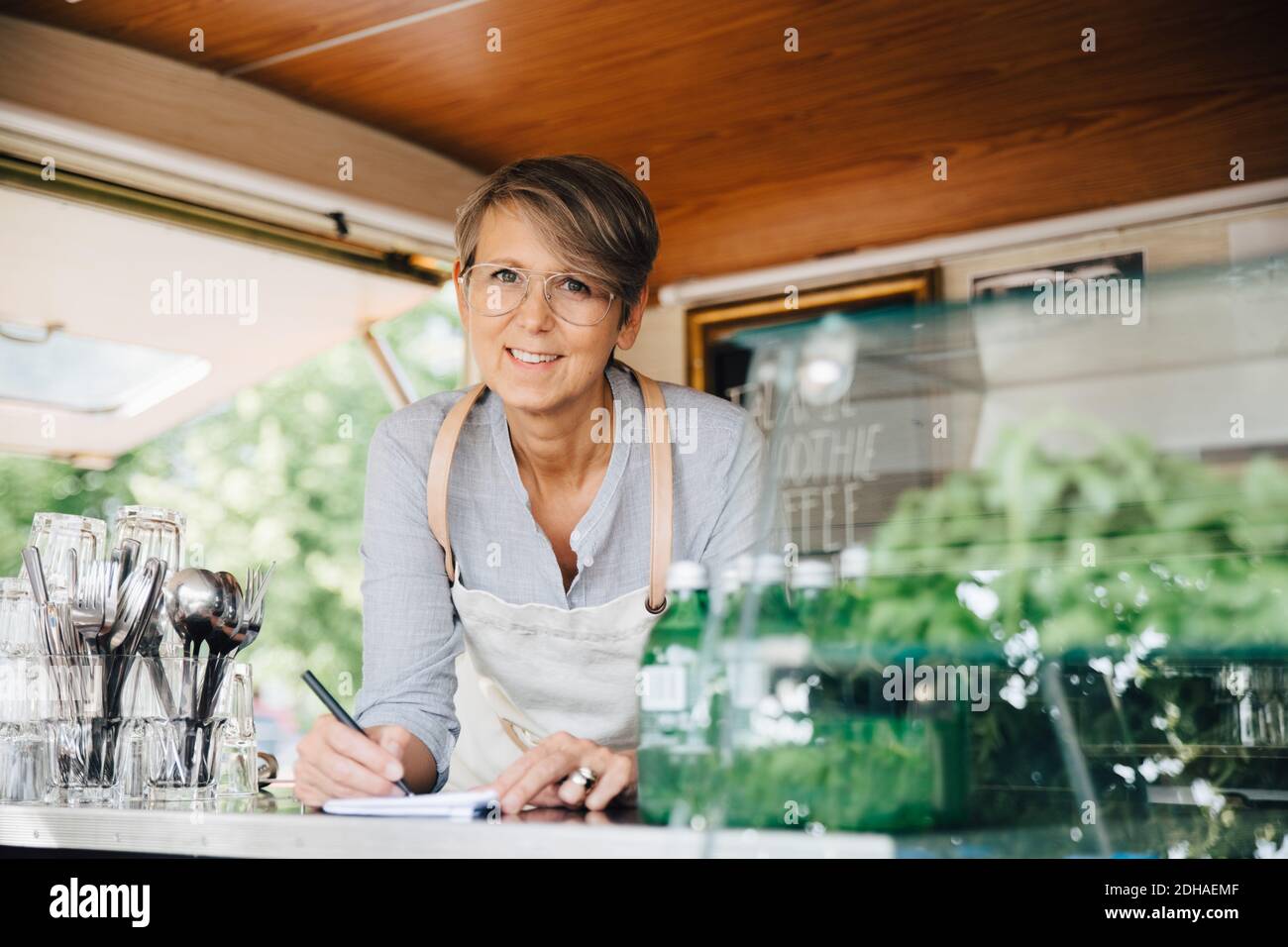 Portrait du propriétaire mature qui prend l'ordre tout en se tenant dans la nourriture chariot Banque D'Images