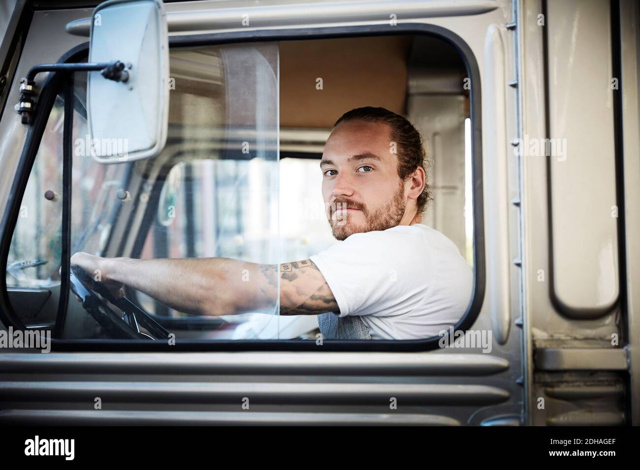 Portrait d'un jeune homme conduisant un camion alimentaire en ville Banque D'Images