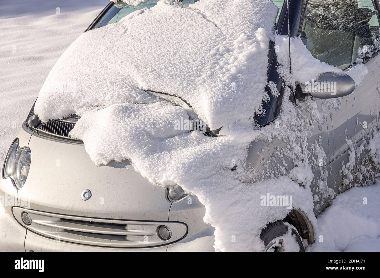 Voiture accidentelle ou tout-terrain de la marque Smart. Verunfaltes und von der Straße abgekommenes eingeschneites Auto der Marke Smart. Banque D'Images