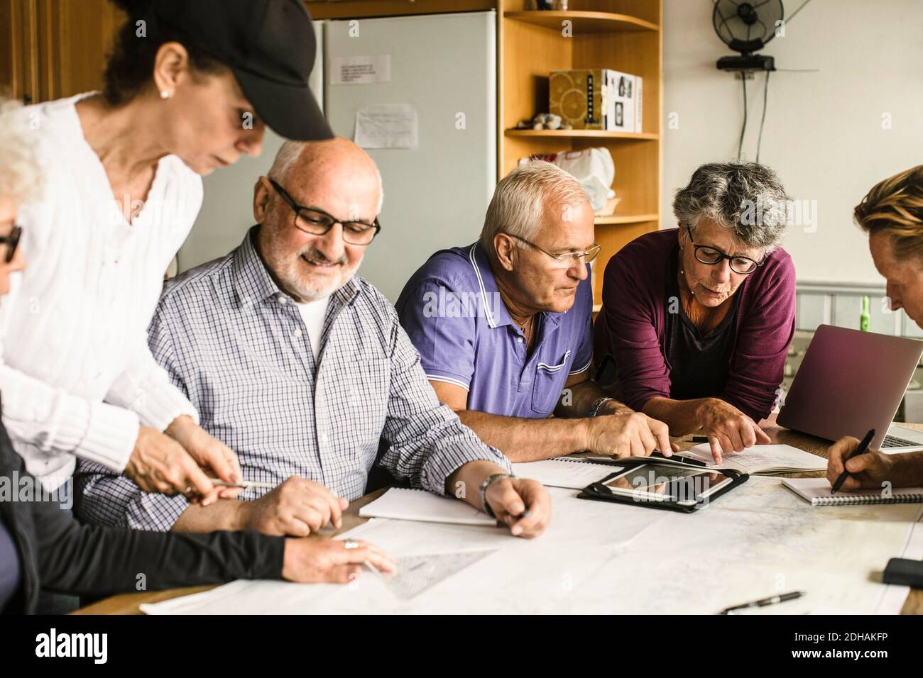 Hommes et femmes âgés discutant à table pendant le cours de navigation Banque D'Images