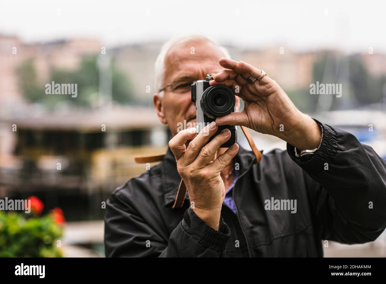 Homme senior utilisant l'appareil photo pendant le cours de photographie Banque D'Images