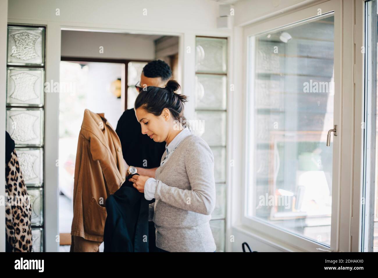 Homme et femme regardant des vestes en se tenant à la maison Banque D'Images