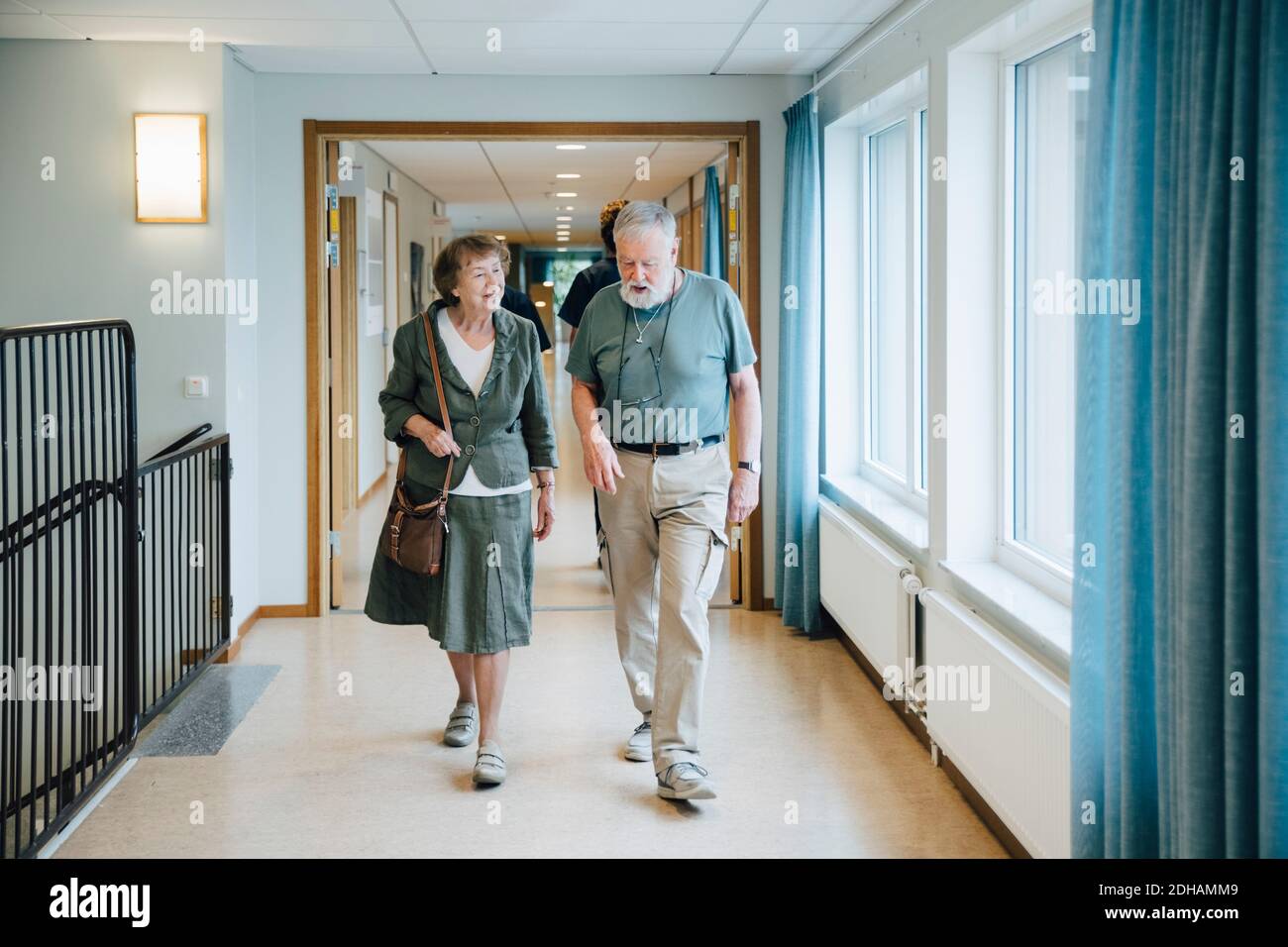 Une longue longueur de couple senior marchant dans une ruelle chez des personnes âgées maison de soins Banque D'Images