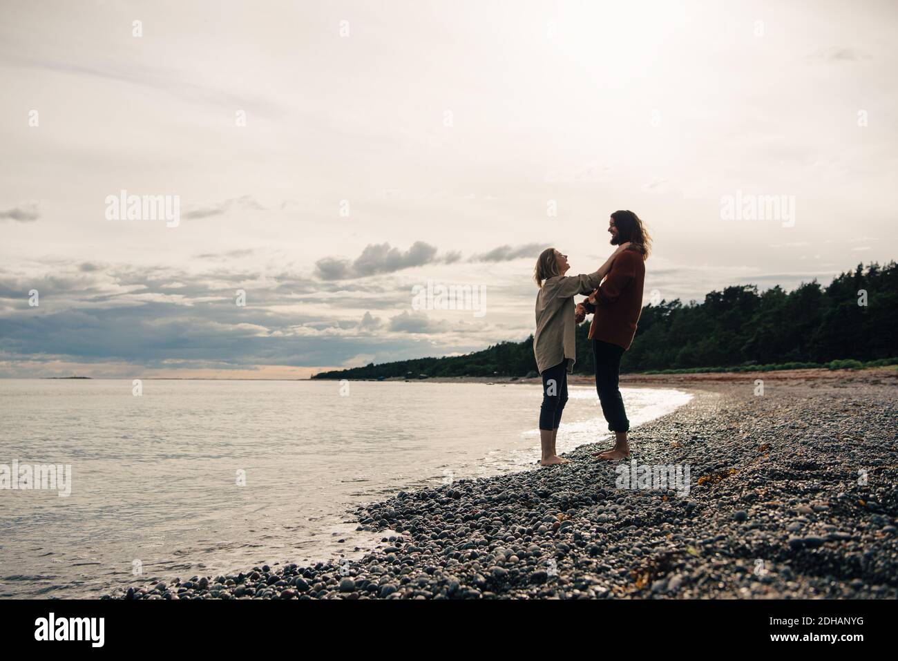 Couple debout sur la rive de la mer à la plage contre le ciel Banque D'Images