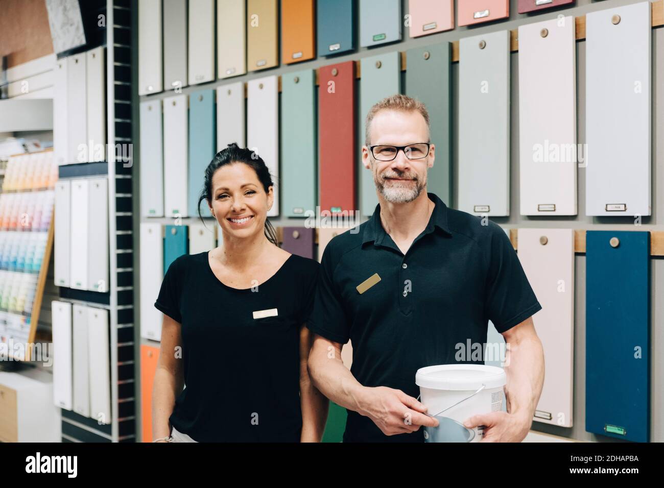 Portrait de collègues souriants debout contre un mur multicolore à l'intérieur stocker Banque D'Images