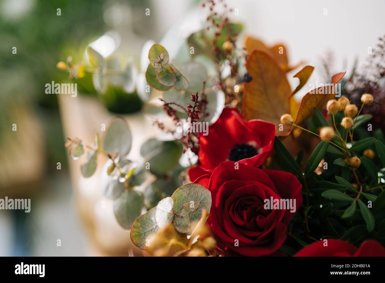 Fond floral, texture. Bouquet rouge, arrangement de fleurs par fleuriste avec roses rouges, coquelicots et feuilles d'eucalyptus gros plan, macro Banque D'Images