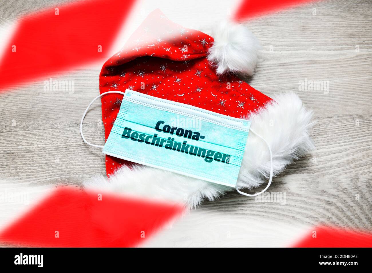 FOTOMONTAGE, Schutzmaske auf Weihnachtsmannmütze mit der Aufschrift Corona-Beschränkungen, Weihnachtsfest zu Corona-Zeiten Banque D'Images