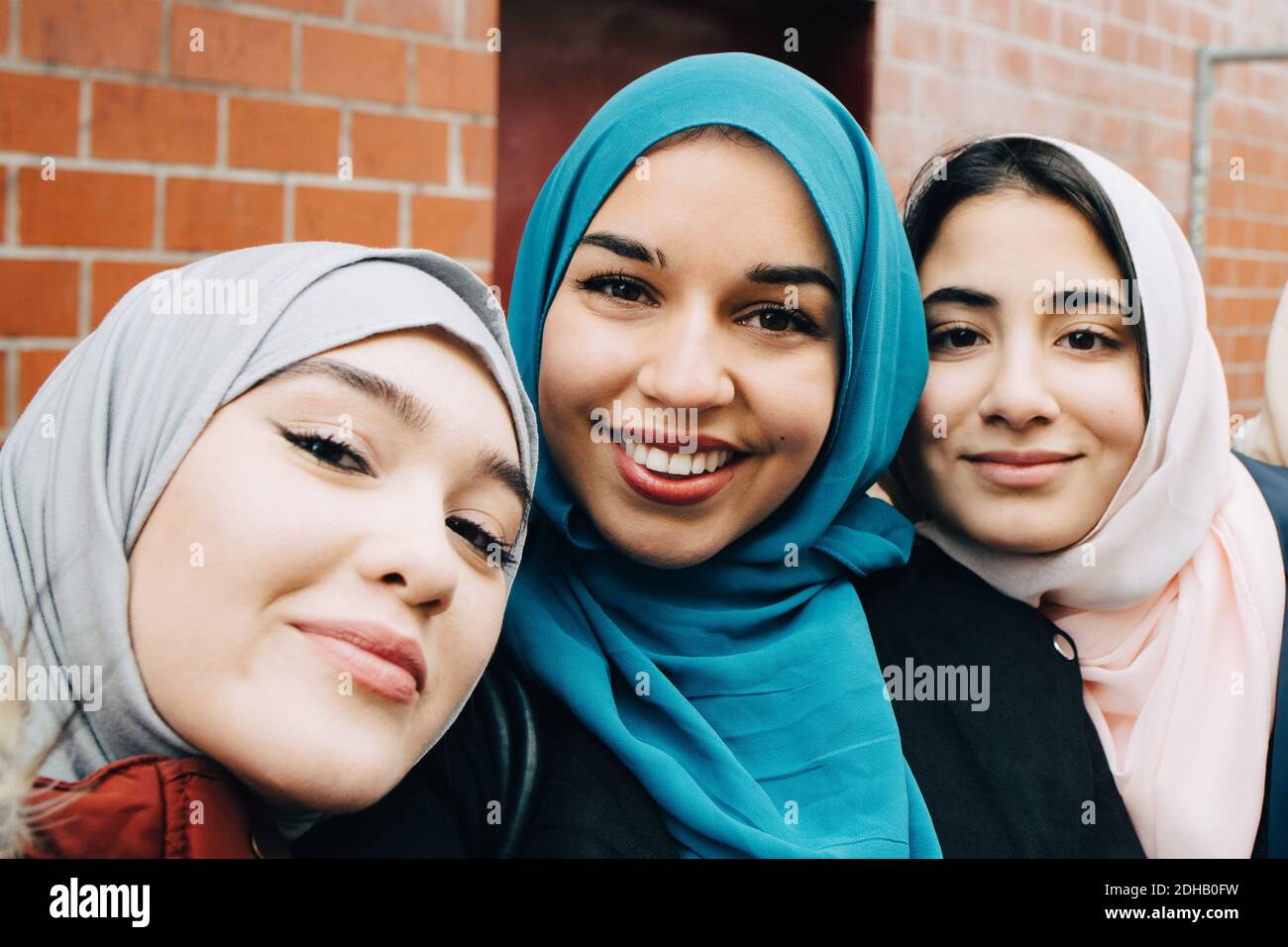 Portrait d'amis musulmans souriants contre la construction en ville Banque D'Images