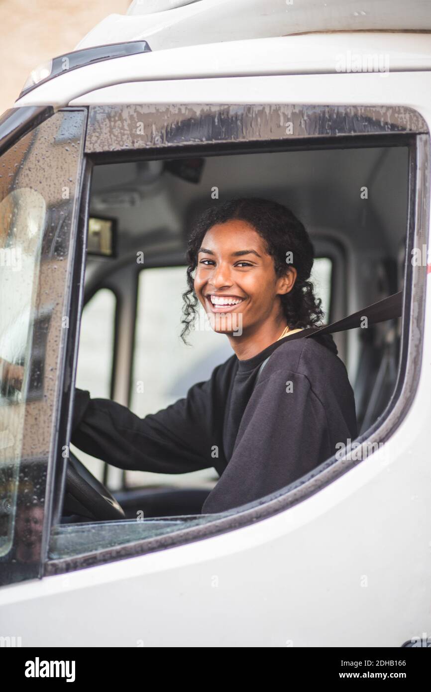 Portrait d'une femme souriante qui conduit un camion Banque D'Images