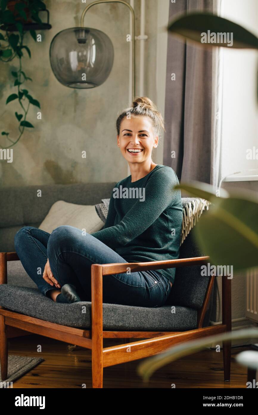 Portrait d'une femme de taille moyenne souriante assise sur un fauteuil accueil Banque D'Images