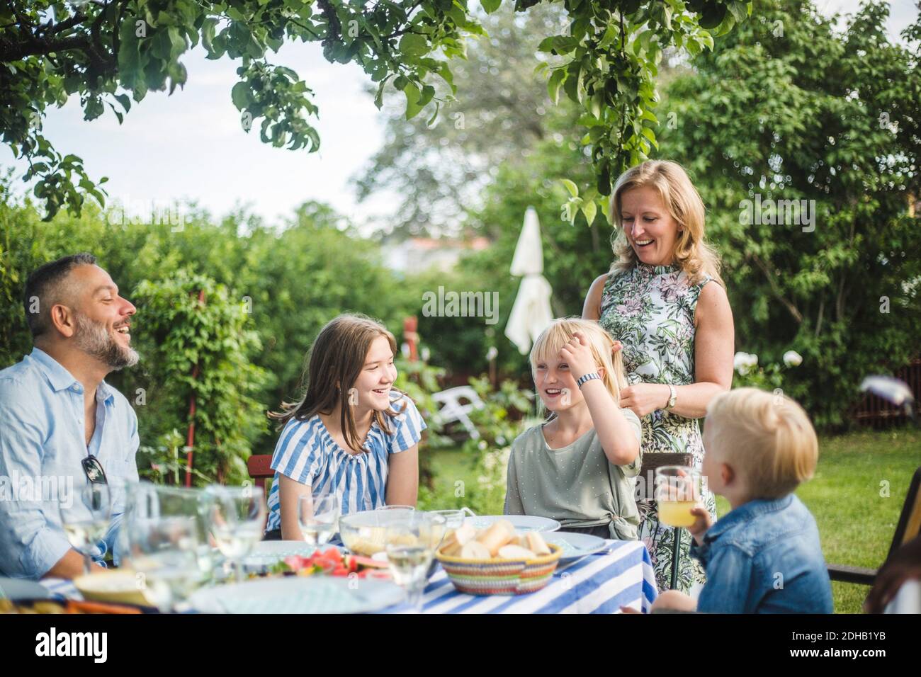 En famille, s'amuser à la table à manger dans le jardin pendant la fête week-end d'été Banque D'Images